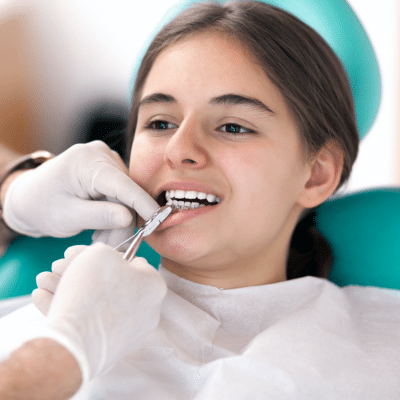 Young girl at orthodontist, getting her braces worked on, representing orthodontic appliances