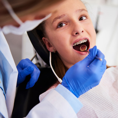 orthodontist examining child's teeth