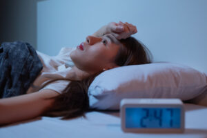 Asian women opened eyes lying on the bed have an insomnia problems.