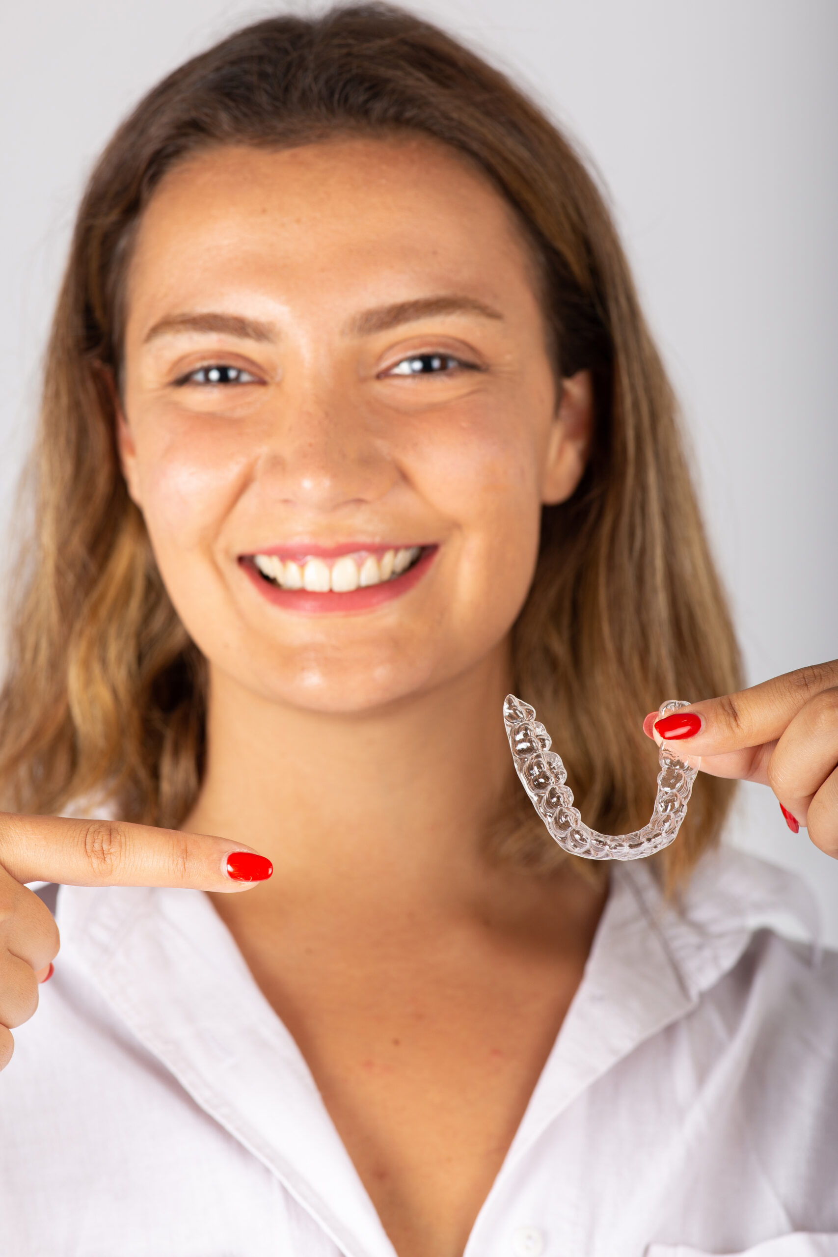 Happy young woman with invisible teeth aligner.