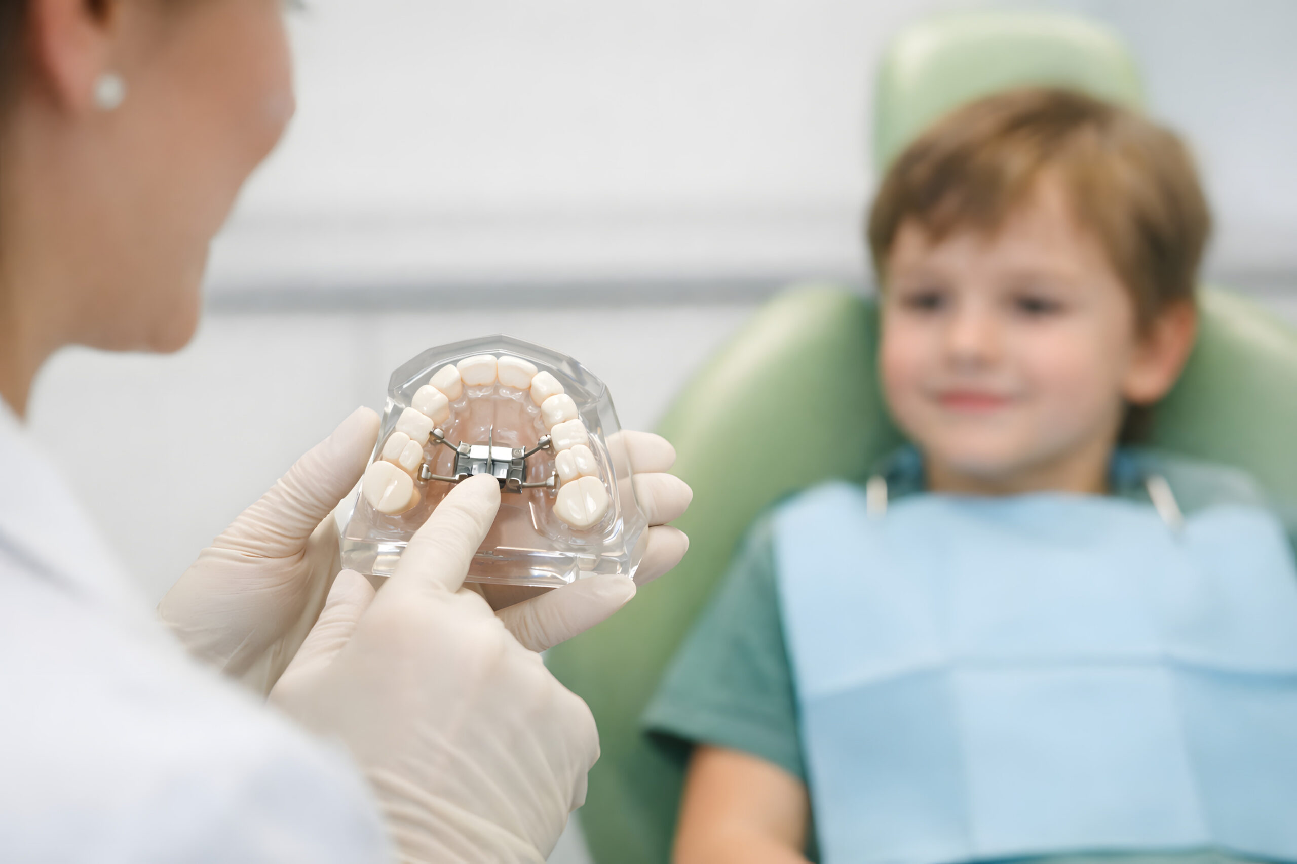 Pediatric Dentist Explaining Palatal Expander to Child During Orthodontic Consultation