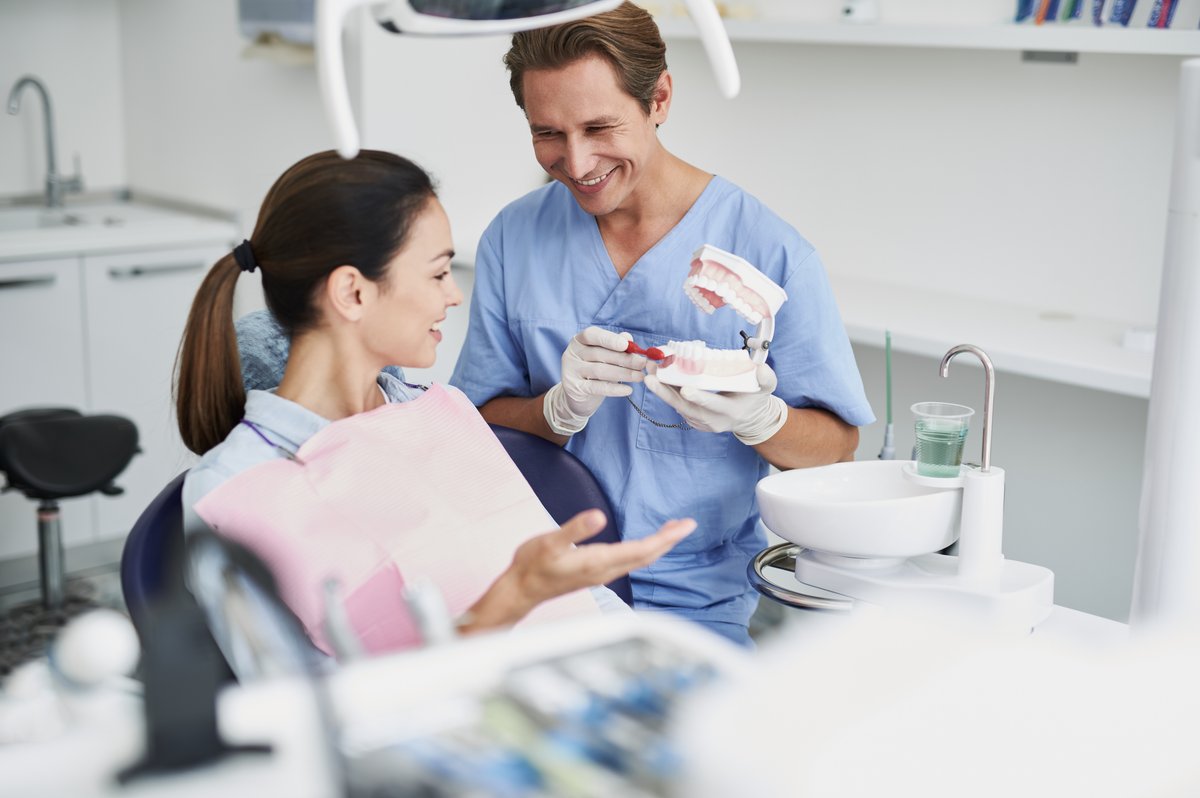 Orthodontist showing a patient a bite model to explain overjet and overbite